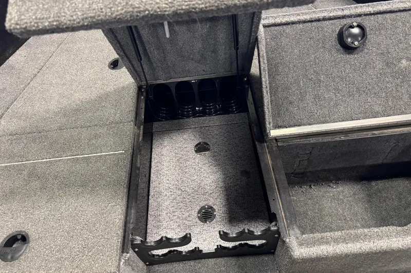 Slide: The Image of 2020 Alumacraft Competitor 165 Tiller boat storage compartment with carpeted interior and rod holders. - 12