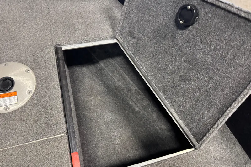 Slide: The Image of 2020 Alumacraft Competitor 165 Tiller boat storage compartment with open lid. - 13