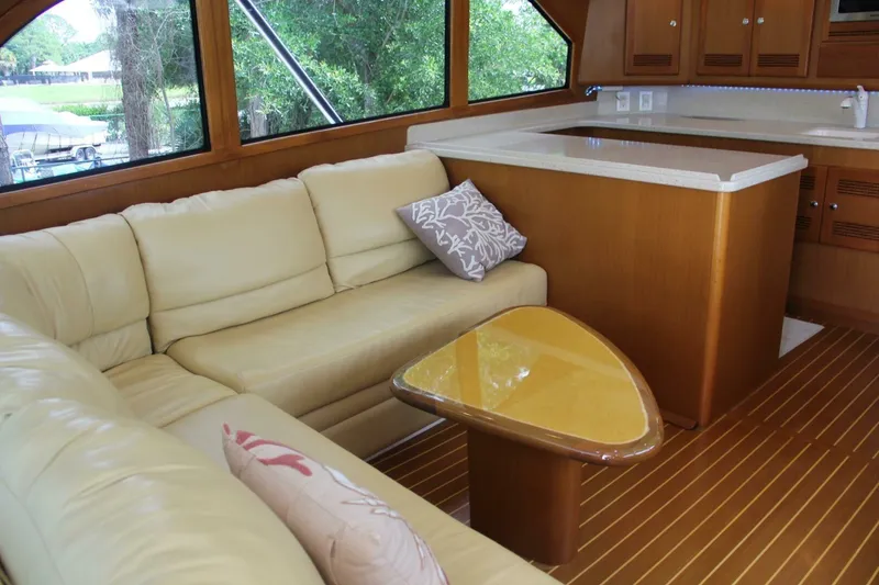 Slide: The Image of Luxurious interior of 2004 Cabo 48 Flybridge yacht with cream leather seating and wooden accents. - 11