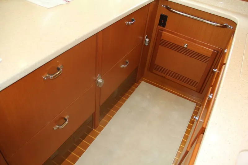 Slide: The Image of 2004 Cabo 48 Flybridge yacht kitchen with wooden cabinets and beige countertops. - 19