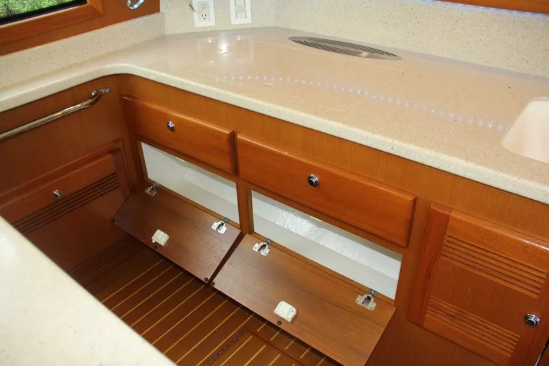 Slide: The Image of 2004 Cabo 48 Flybridge yacht interior with wooden cabinets and beige countertop. - 23