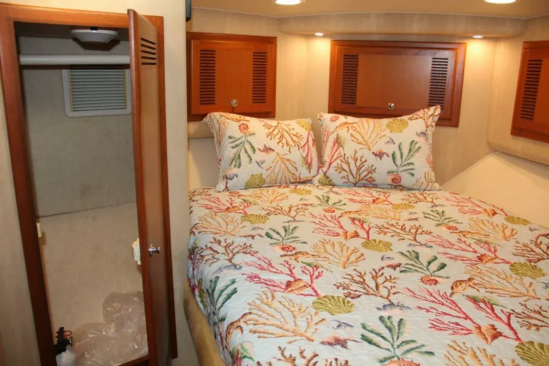 Slide: The Image of Cozy cabin interior of 2004 Cabo 48 Flybridge with colorful coral-themed bedding. - 27