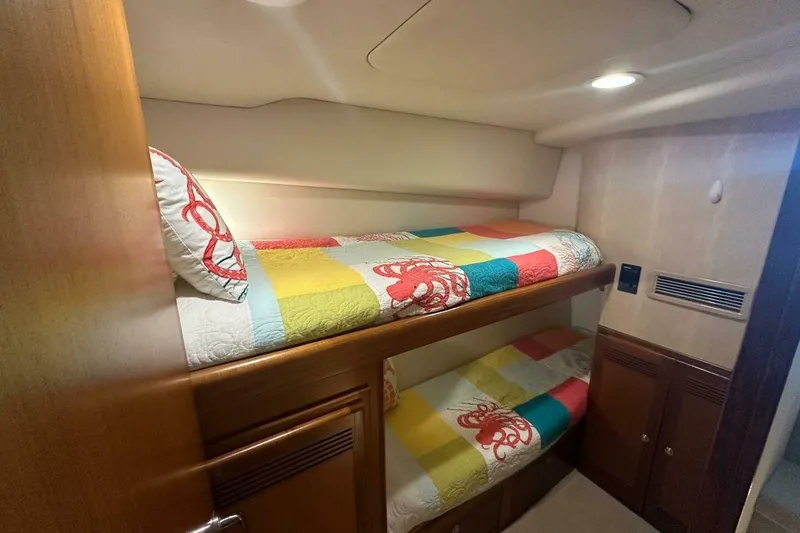 Slide: The Image of Bunk beds in 2004 Cabo 48 Flybridge yacht cabin with colorful bedding. - 29