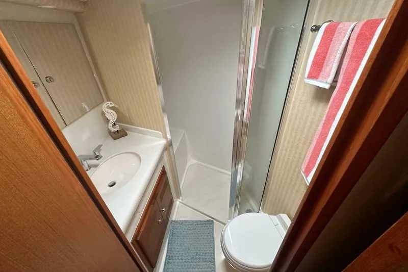 Slide: The Image of Bathroom interior of 2004 Cabo 48 Flybridge yacht with shower, sink, and toilet. - 35