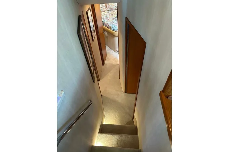 Slide: The Image of Stairway inside 2004 Cabo 48 Flybridge yacht, leading to a cozy cabin area. - 39