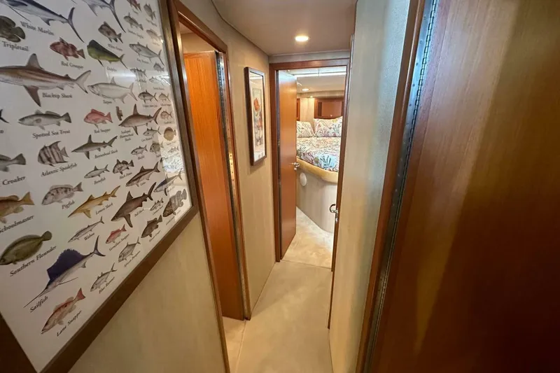 Slide: The Image of Hallway inside 2004 Cabo 48 Flybridge yacht with fish chart and cozy bedroom view. - 40