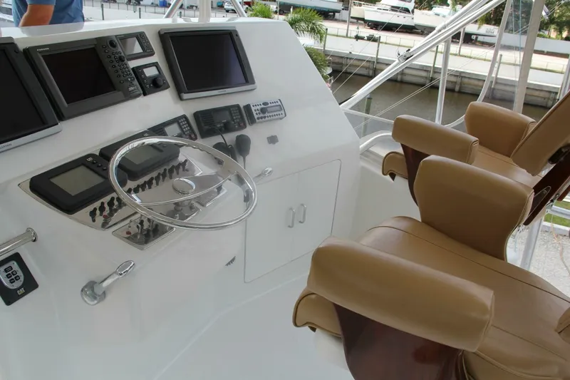 Slide: The Image of 2004 Cabo 48 Flybridge helm with navigation equipment and leather captain's chairs. - 46