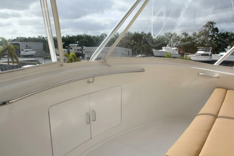 Slide: The Image of 2004 Cabo 48 Flybridge interior with beige seating and marina view. - 48