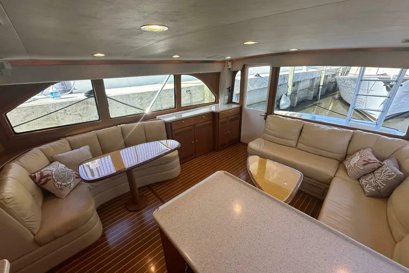 Slide: The Image of Luxurious 2004 Cabo 48 Flybridge yacht interior with plush seating and elegant wood finishes. - 5