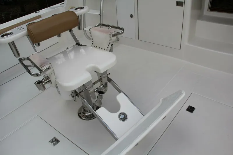 Slide: The Image of 2004 Cabo 48 Flybridge fishing chair with rod holders and footrest in white deck area. - 51