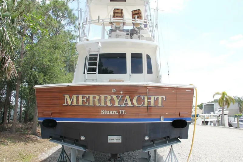 Slide: The Image of 2004 Cabo 48 Flybridge yacht "Merryacht" in Stuart, FL, docked with lush greenery. - 52
