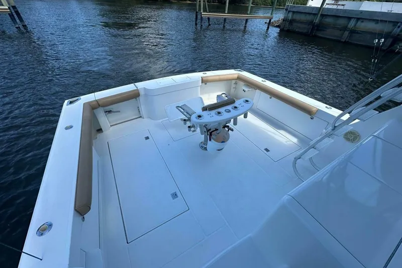 Slide: The Image of 2004 Cabo 48 Flybridge boat deck with fishing station, docked on calm water. - 57