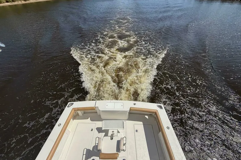 Slide: The Image of 2004 Cabo 48 Flybridge cruising on open water, view from the stern. - 58