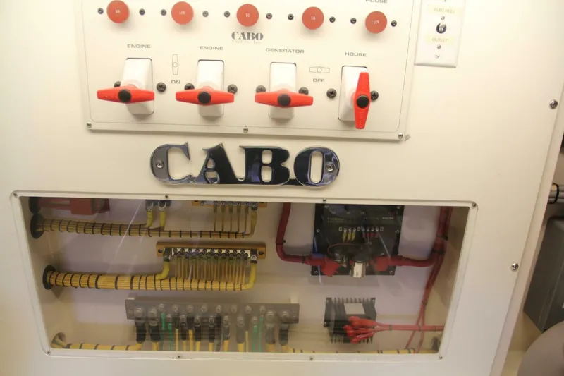 Slide: The Image of Control panel of a 2004 Cabo 48 Flybridge yacht with labeled switches and wiring. - 60