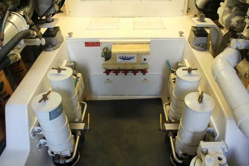 Slide: The Image of Engine room of 2004 Cabo 48 Flybridge with fuel filters and mechanical components. - 63