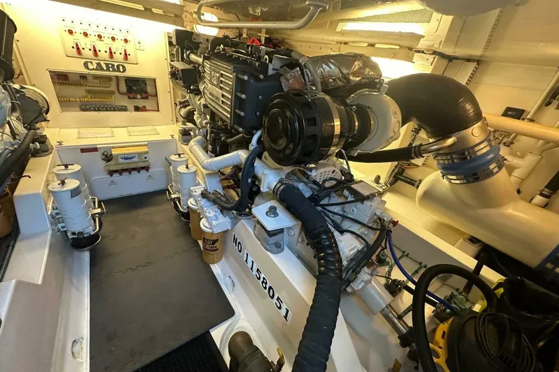 Slide: The Image of Engine room of a 2004 Cabo 48 Flybridge yacht, showcasing detailed machinery and components. - 66