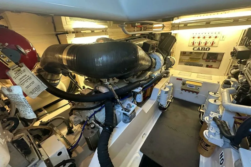 Slide: The Image of Engine room of a 2004 Cabo 48 Flybridge yacht, showcasing mechanical components and systems. - 67