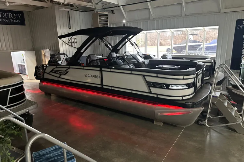Slide: The Image of 2026 Godfrey AP 255 DFLW pontoon boat with sleek design and red underglow lighting. - 21