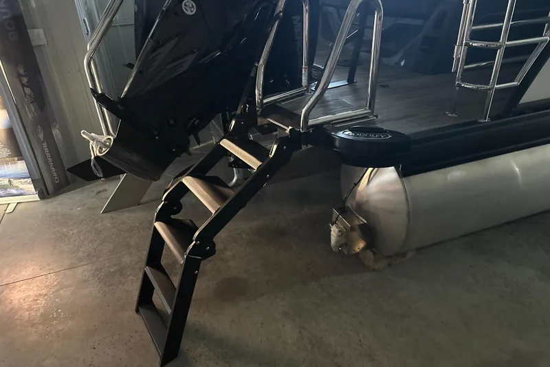 Slide: The Image of 2026 Godfrey AP 255 DFLW boat with ladder and pontoon in a showroom. - 23