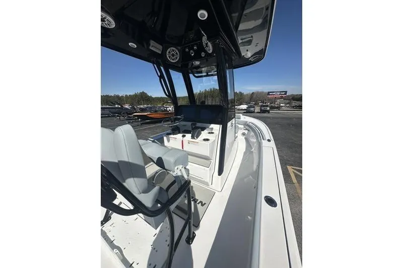 Slide: The Image of 2026 Sportsman Masters 247 Bay Boat interior with seating and console, parked outdoors. - 14