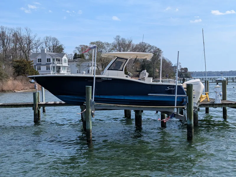Slide: The Image of 2024 Scout 277 LXF boat on a dock by the water. - 31