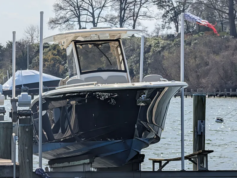 Slide: The Image of 2024 Scout 277 LXF boat docked with flag in background. - 32