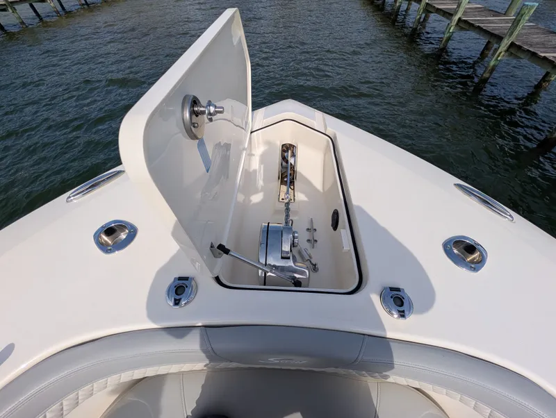 Slide: The Image of 2024 Scout 277 LXF boat with open anchor compartment at dock. - 35