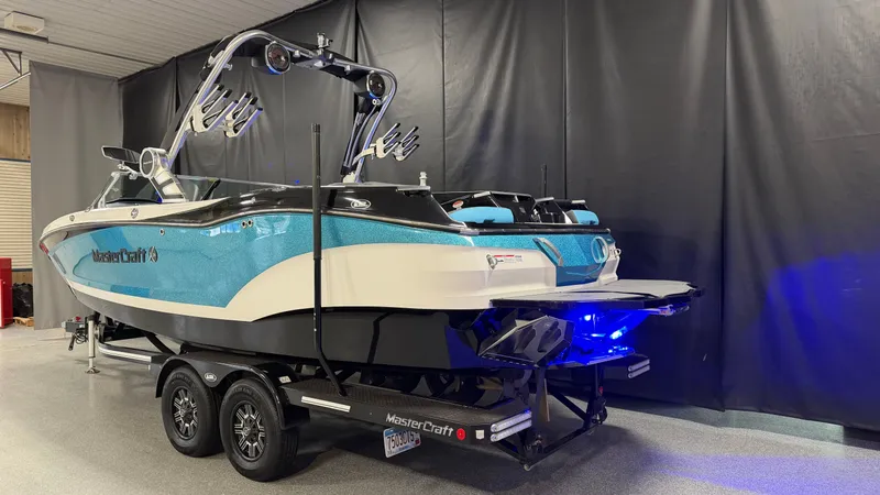 Slide: The Image of 2019 MasterCraft X24 boat with blue hull and trailer in a showroom. - 4