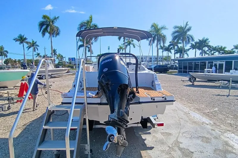 Slide: The Image of 2026 Starcraft SVX 230 DC OB boat with outboard motor, parked outdoors under clear sky. - 10