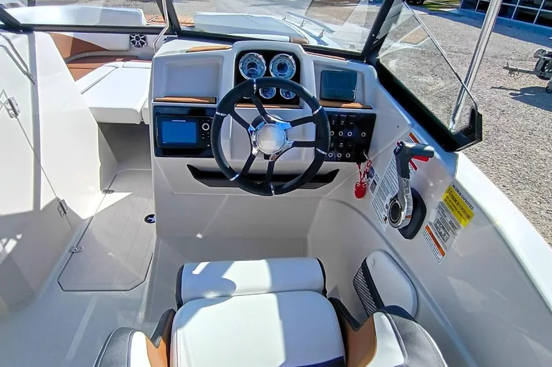 Slide: The Image of 2026 Starcraft SVX 230 DC OB boat cockpit with steering wheel and control panel. - 12