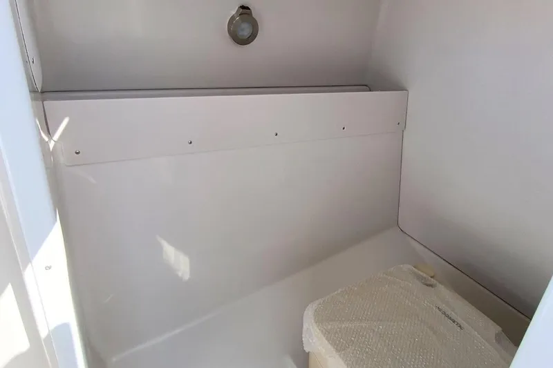 Slide: The Image of Interior of 2026 Starcraft SVX 230 DC OB boat, featuring a compact storage area. - 23