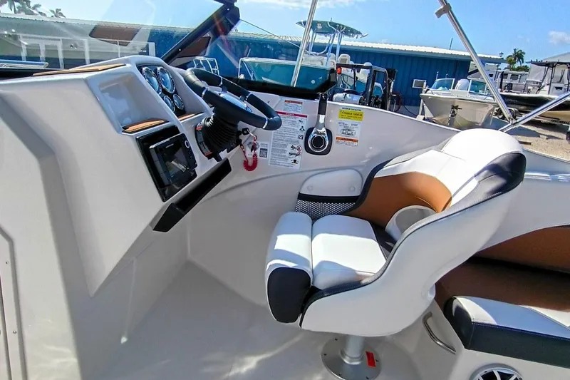 Slide: The Image of Interior of 2026 Starcraft SVX 230 DC OB boat, featuring helm and captain's chair. - 24