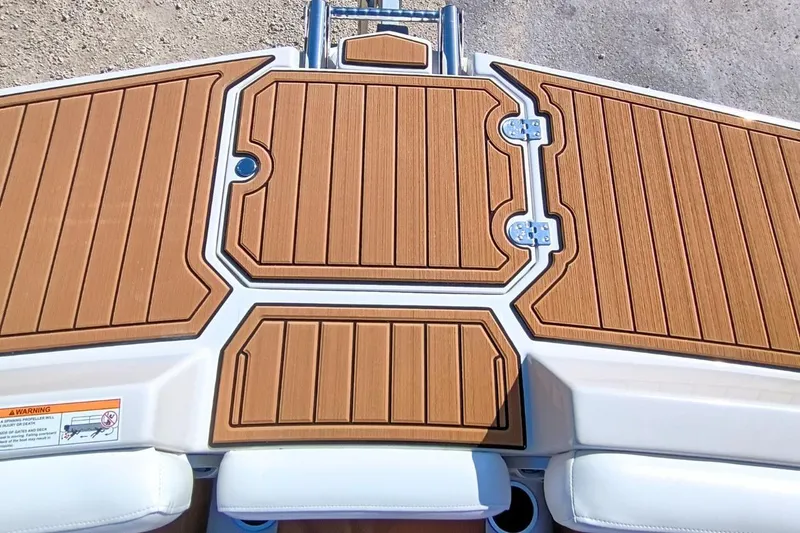 Slide: The Image of 2026 Starcraft SVX 230 DC OB boat deck with wood finish and storage compartments. - 28