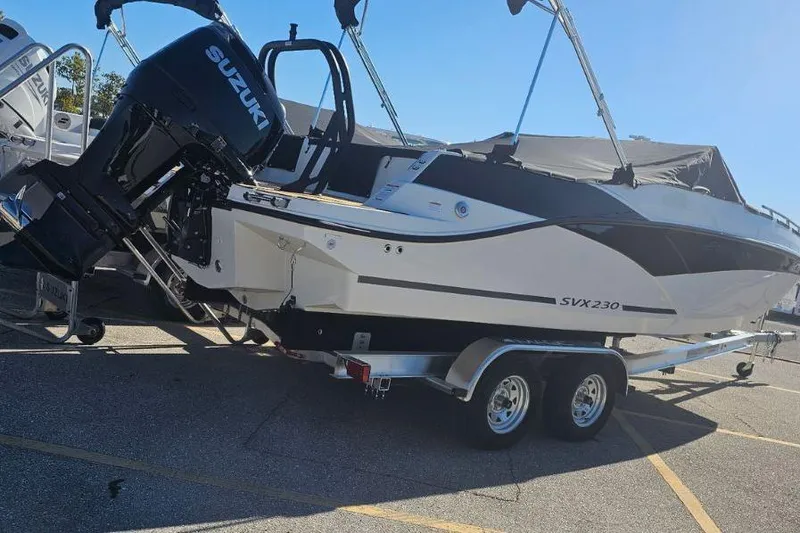 Slide: The Image of 2026 Starcraft SVX 230 DC OB boat with Suzuki outboard engine on trailer. - 3