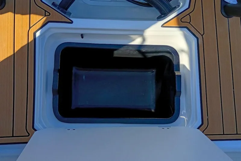 Slide: The Image of Starcraft SVX 230 DC OB 2026 boat storage compartment with wood-like deck flooring. - 43
