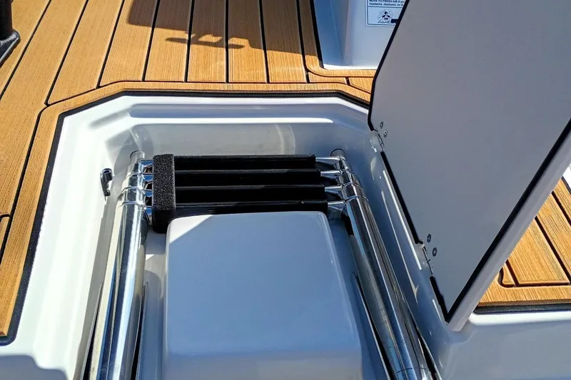 Slide: The Image of 2026 Starcraft SVX 230 DC OB boat ladder compartment with teak-style flooring. - 51