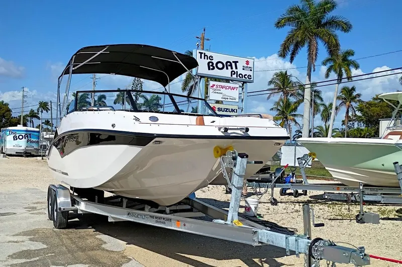 Slide: The Image of 2026 Starcraft SVX 230 DC OB boat on trailer at dealership with palm trees. - 9