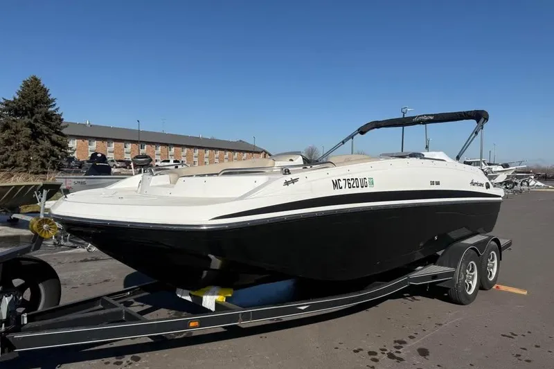 Slide: The Image of 2018 Hurricane SunDeck Sport 188 IO boat on trailer, parked outdoors. - 2