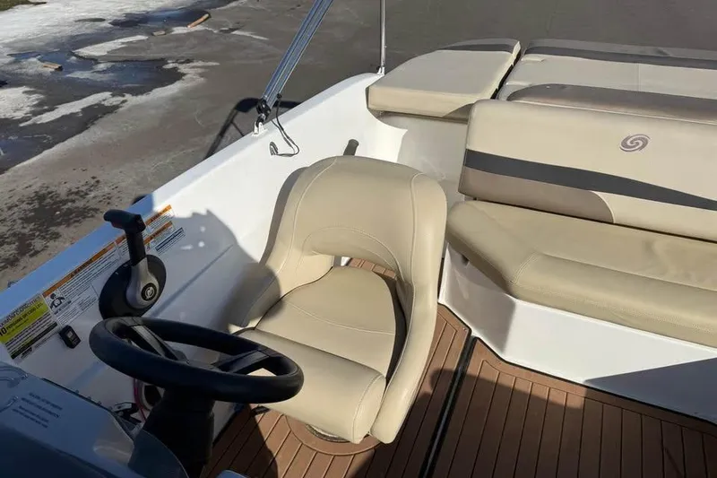 Slide: The Image of 2018 Hurricane SunDeck Sport 188 IO boat interior with beige seating and steering wheel. - 8