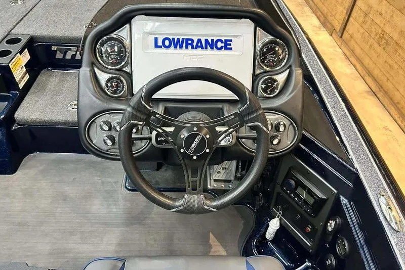 Slide: The Image of 2023 Triton 20 TrX Patriot boat dashboard with Lowrance display and steering wheel. - 6
