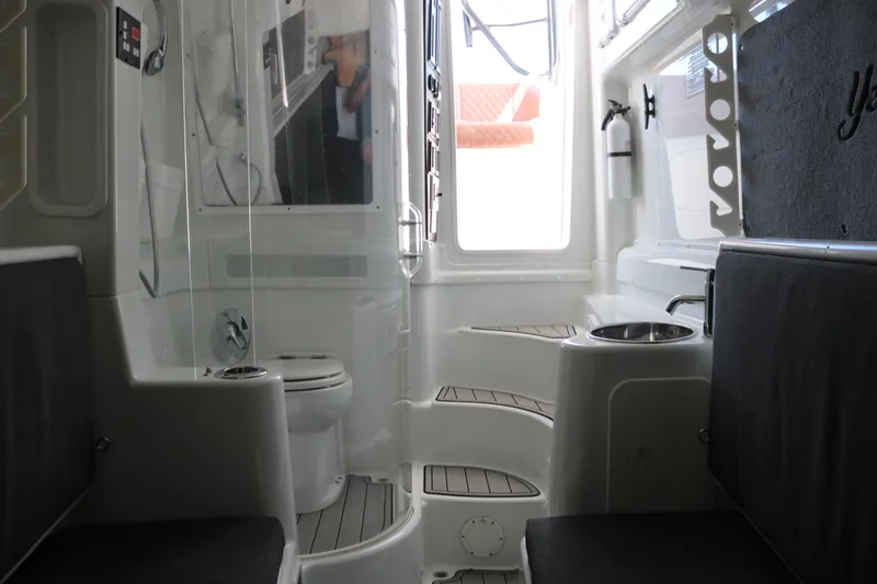 Slide: The Image of Interior of 2008 Yellowfin 42 Offshore boat, featuring seating and a compact bathroom area. - 19