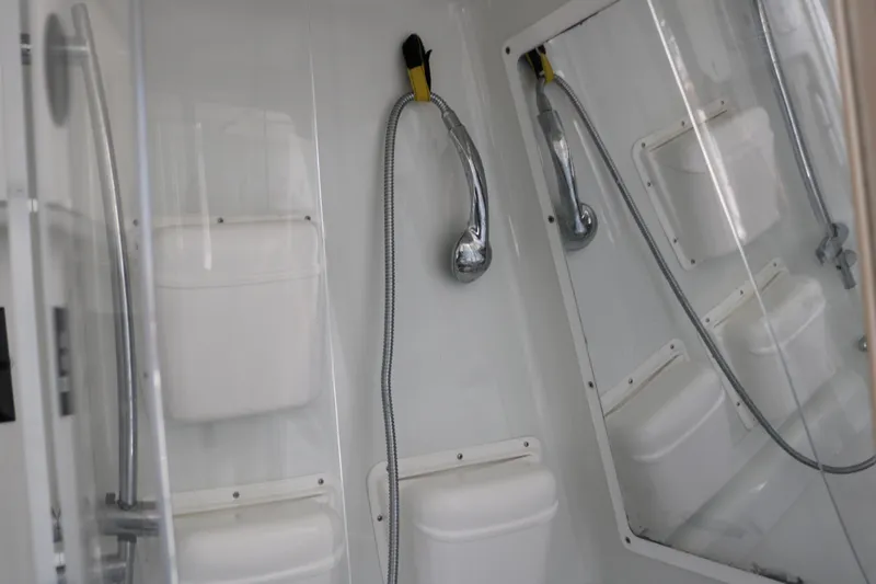 Slide: The Image of 2008 Yellowfin 42 Offshore boat shower with chrome fixtures and white storage compartments. - 21