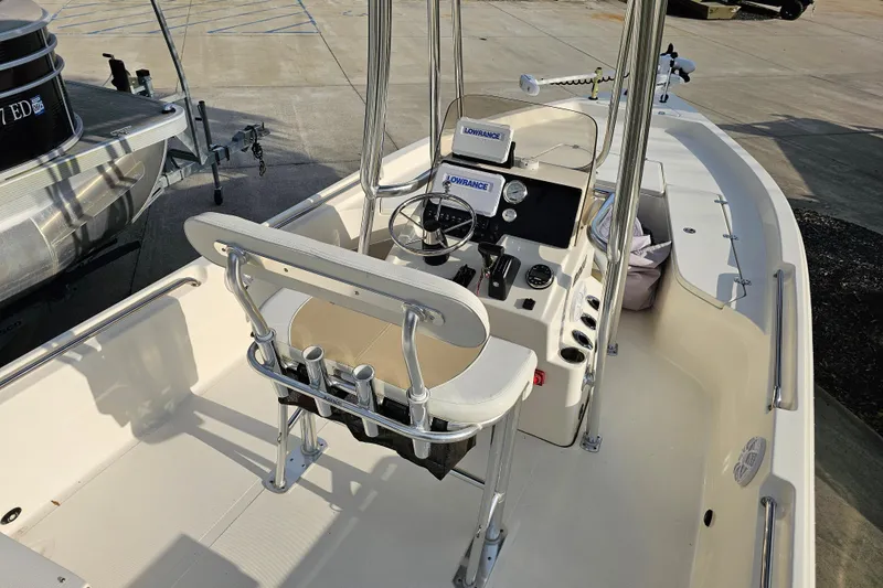 Slide: The Image of 2024 Bulls Bay 2200 boat interior with steering console and seating, docked outdoors. - 6