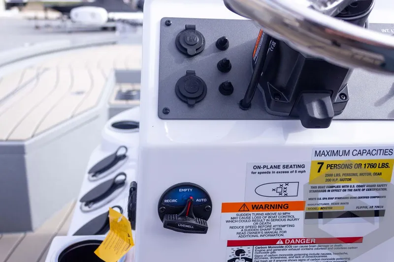 Slide: The Image of 2026 Vexus ACX 2150 boat dashboard with controls and safety warnings. - 41