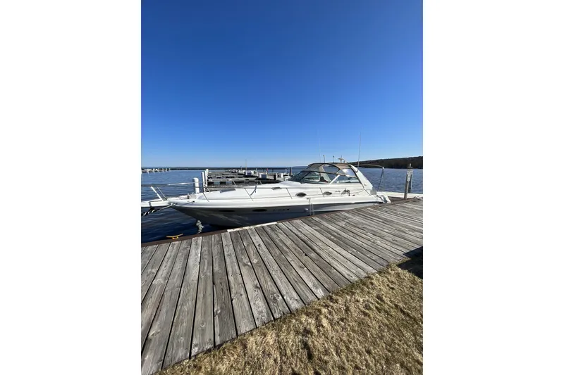 Slide: The Image of 1996 Sea Ray Sundancer 330 docked at a marina under clear blue skies. - 3