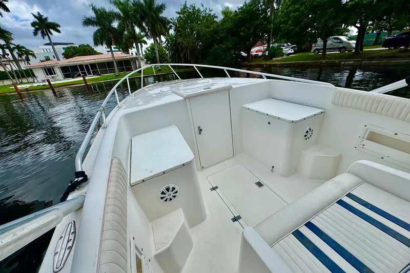 Slide: The Image of 1996 Marlin 35 CC Sportfish boat interior with seating and storage, docked near palm trees. - 24