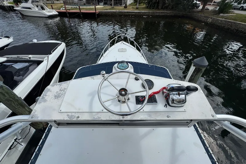 Slide: The Image of 1996 Marlin 35 CC Sportfish w/Cuddy helm view, docked near other boats. - 34