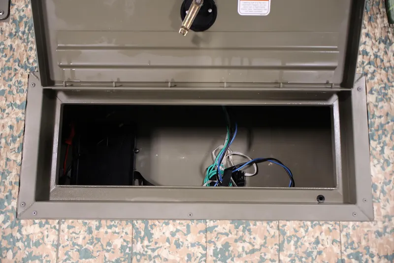Slide: The Image of Open storage compartment in 2022 Tracker Grizzly 2072 MVX CC boat, showing wiring and interior. - 14