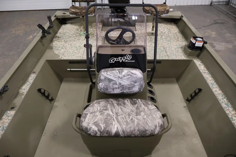 Slide: The Image of 2022 Tracker Grizzly 2072 MVX CC boat interior with camouflage seats and steering console. - 18