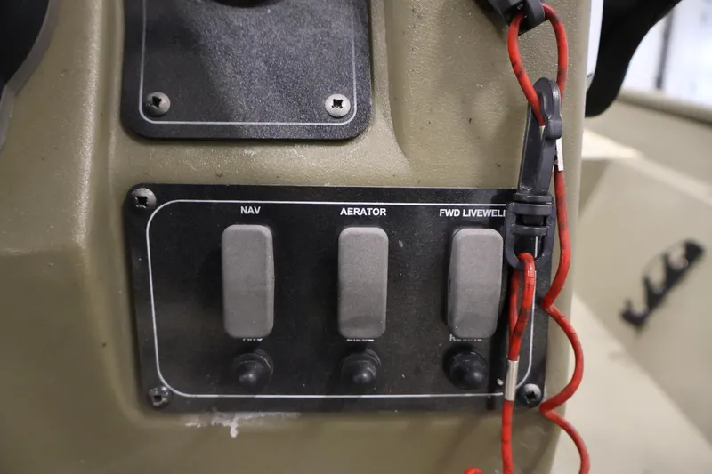 Slide: The Image of Control panel of 2022 Tracker Grizzly 2072 MVX CC boat with switches and red cord. - 28